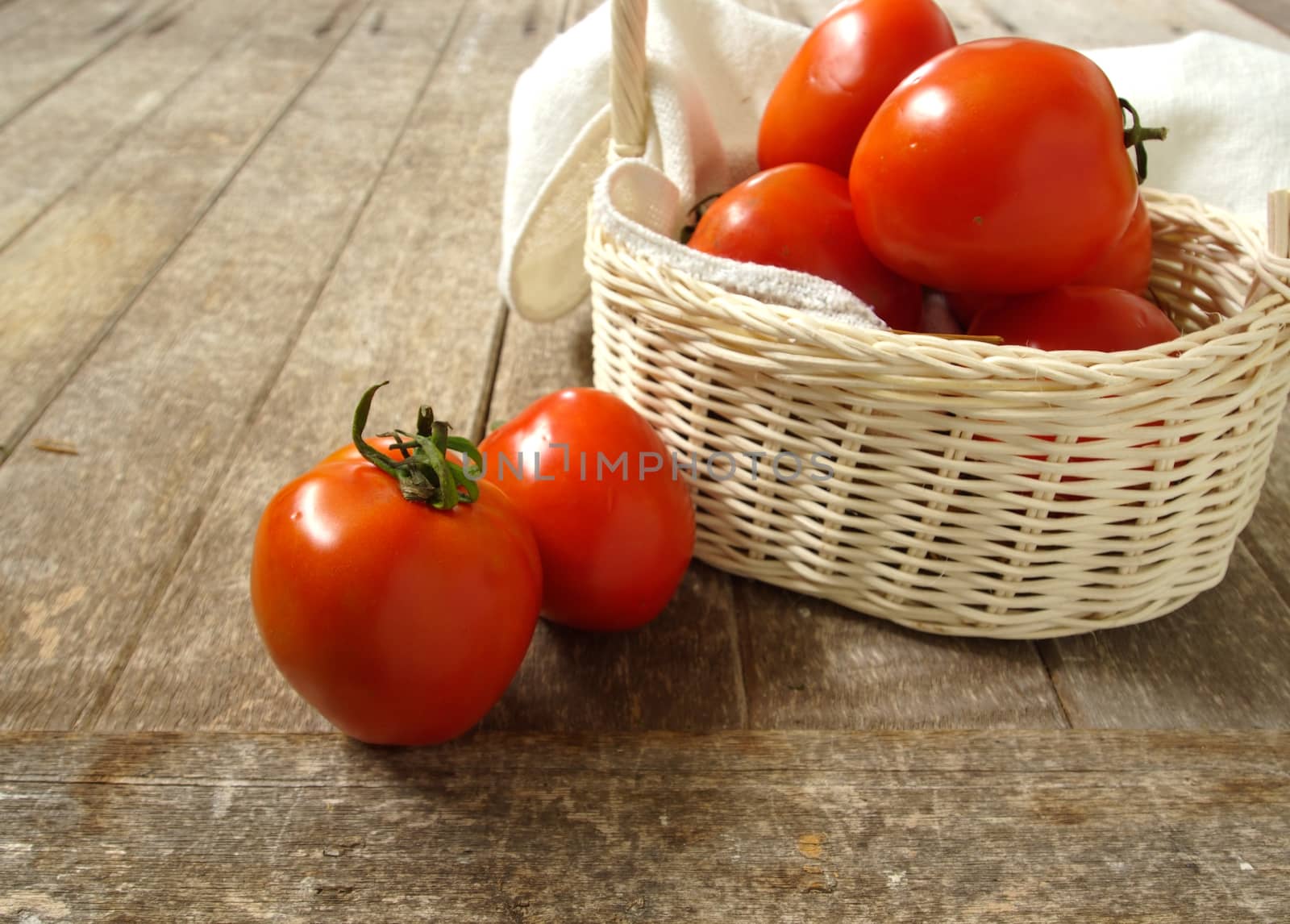 tomatoes in basket on wooden background