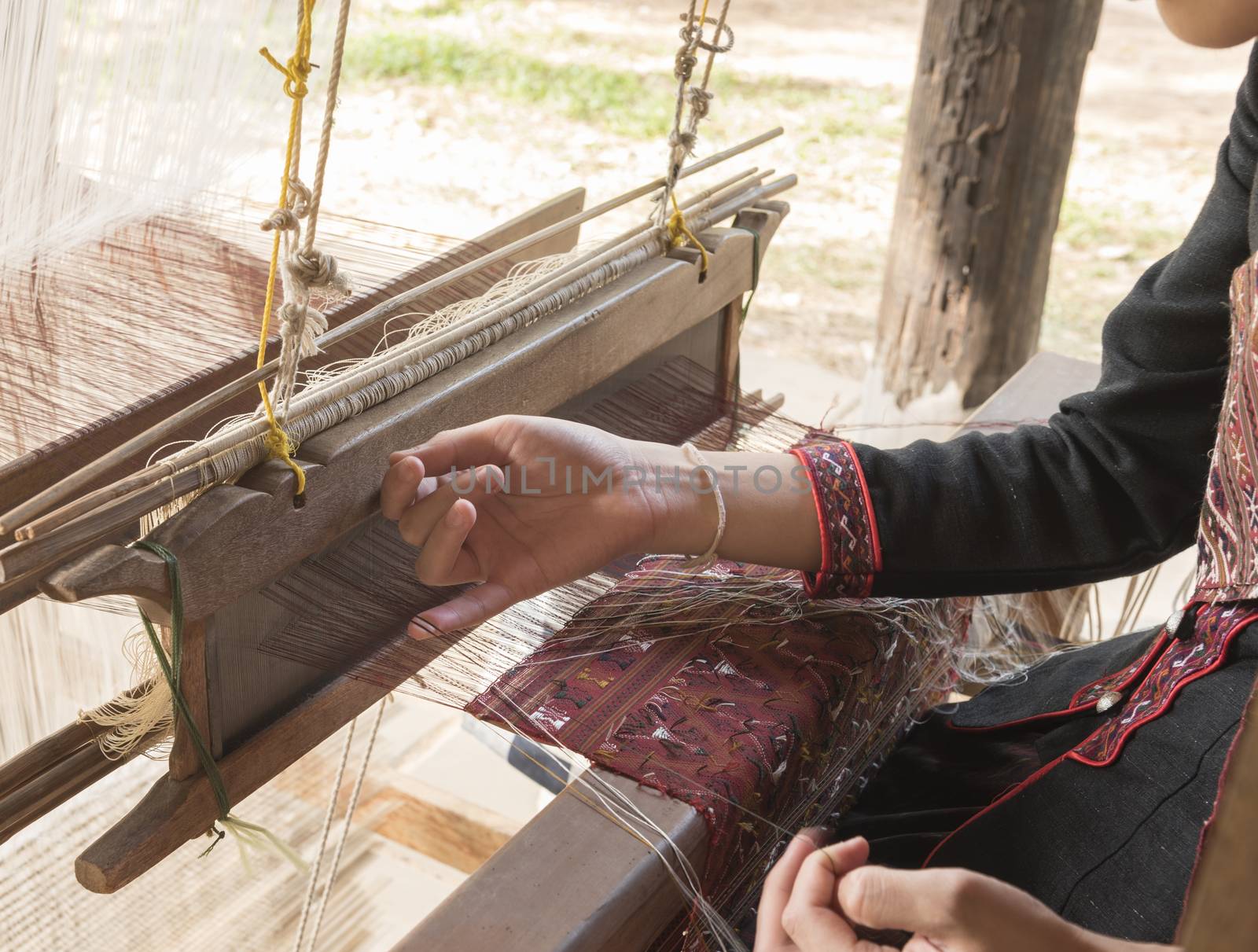 The girl was sitting with hand weaving.