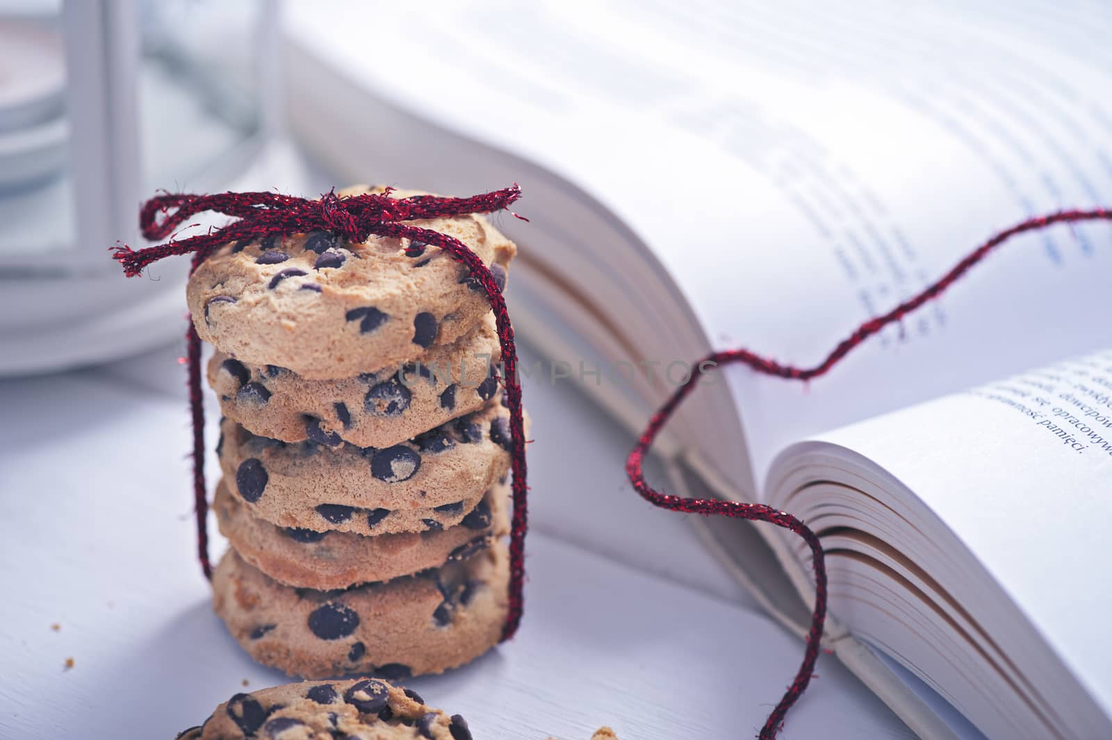American cookies with chocolate next to the book on white table by Michalowski