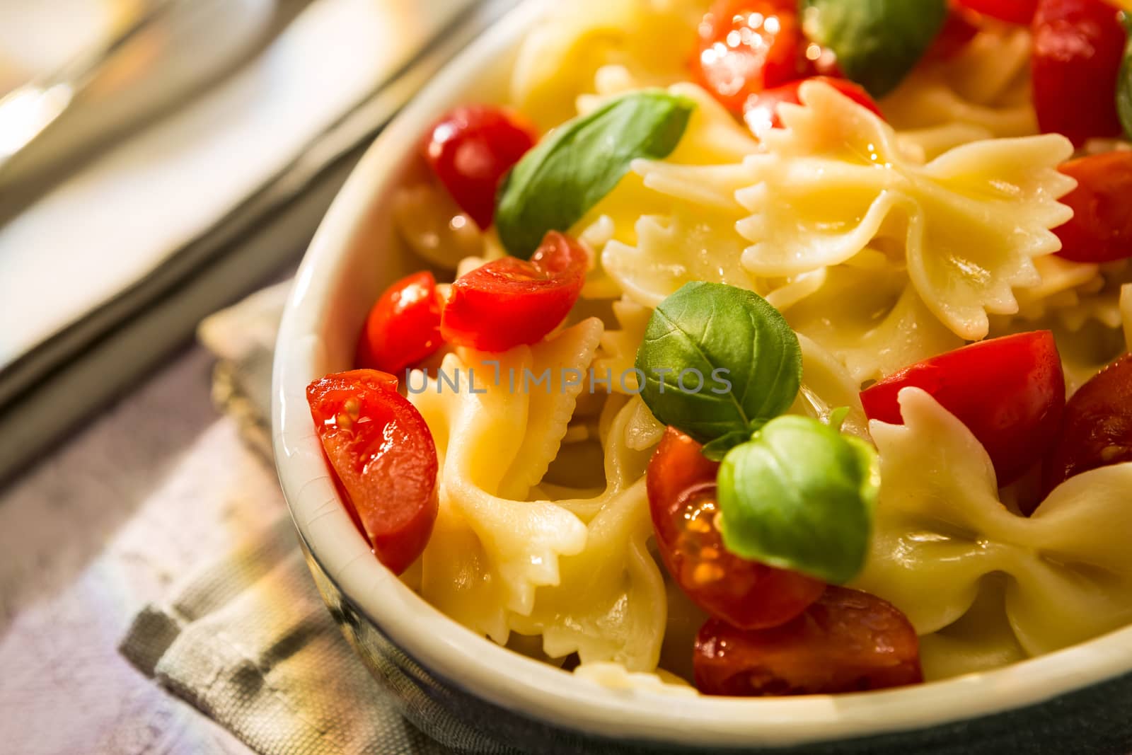 Closeup of Italian Farfalle pasta with tomatoes and basil by LuigiMorbidelli