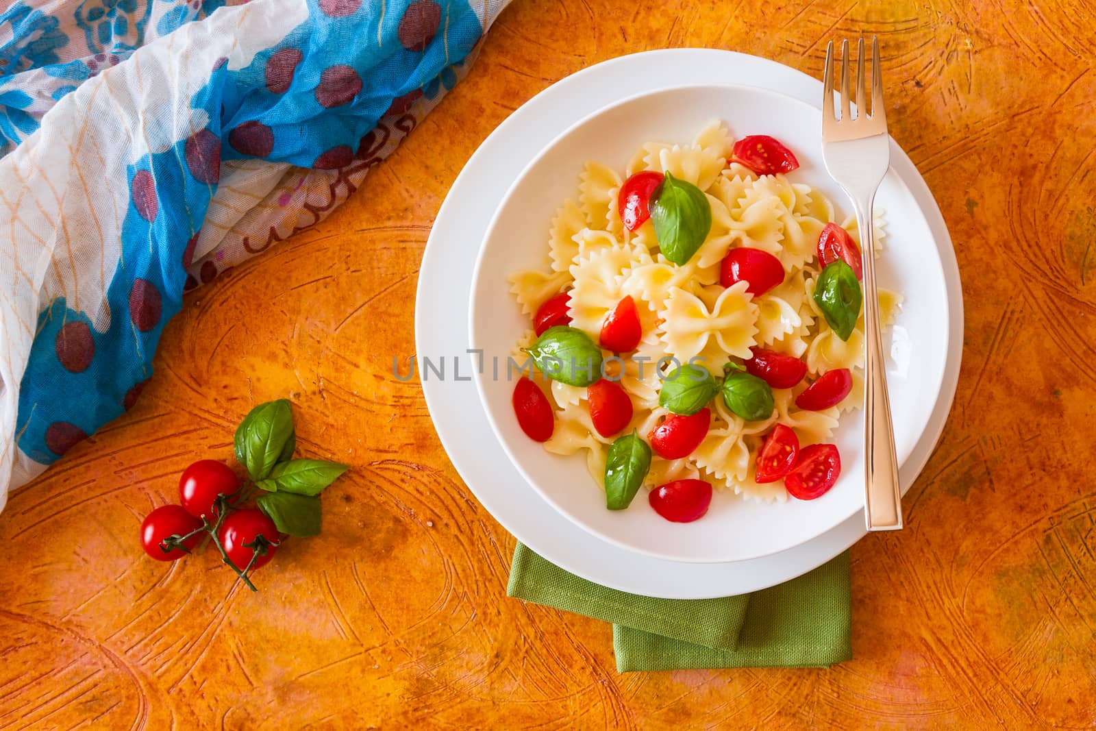 Farfalle pasta with cherry tomatoes and basil seen from above by LuigiMorbidelli
