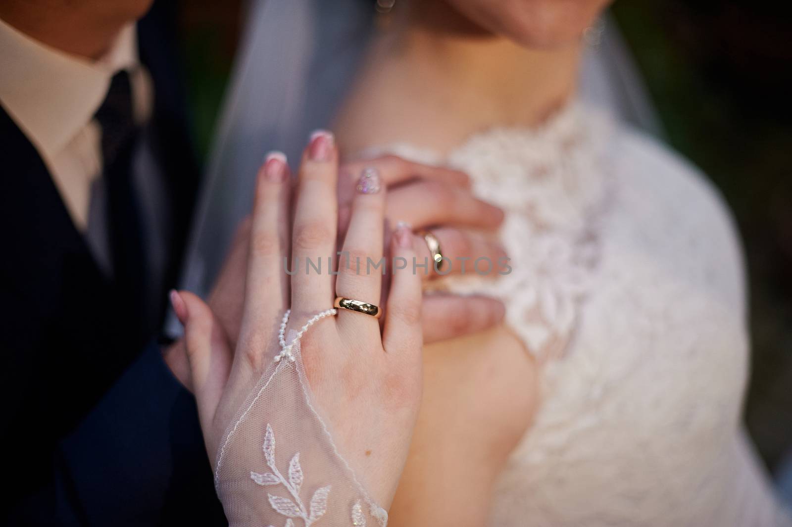 bride and groom show hands with wedding gold rings by timonko