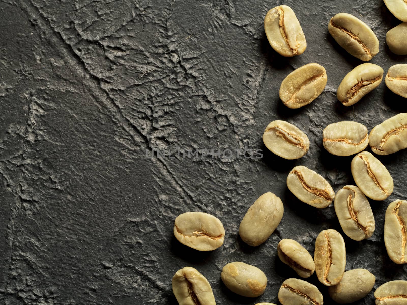 Green coffee beans on dark concrete background. Top view or flat lay. Copy space. Image with natural colors