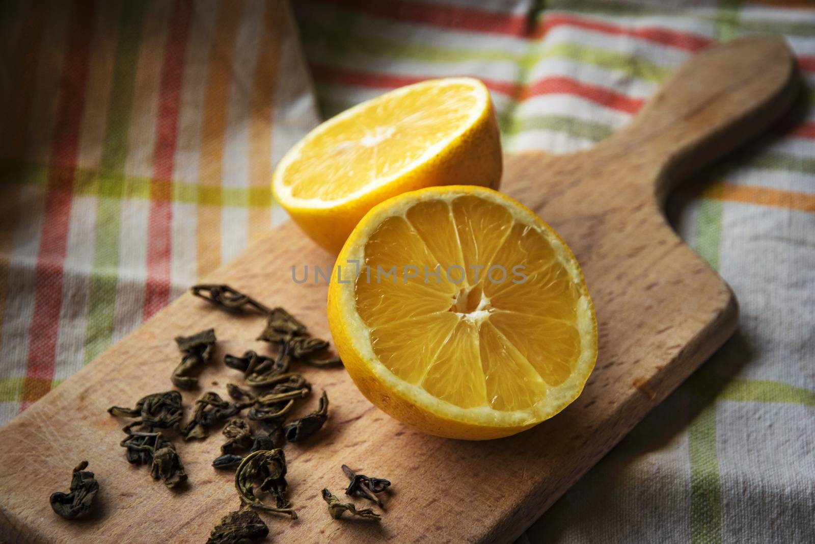 Still life with spill split in half lemon green tea on a wooden board