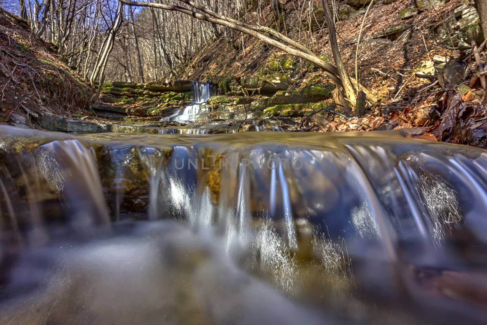 close view of water in small river with rocks in the mountain