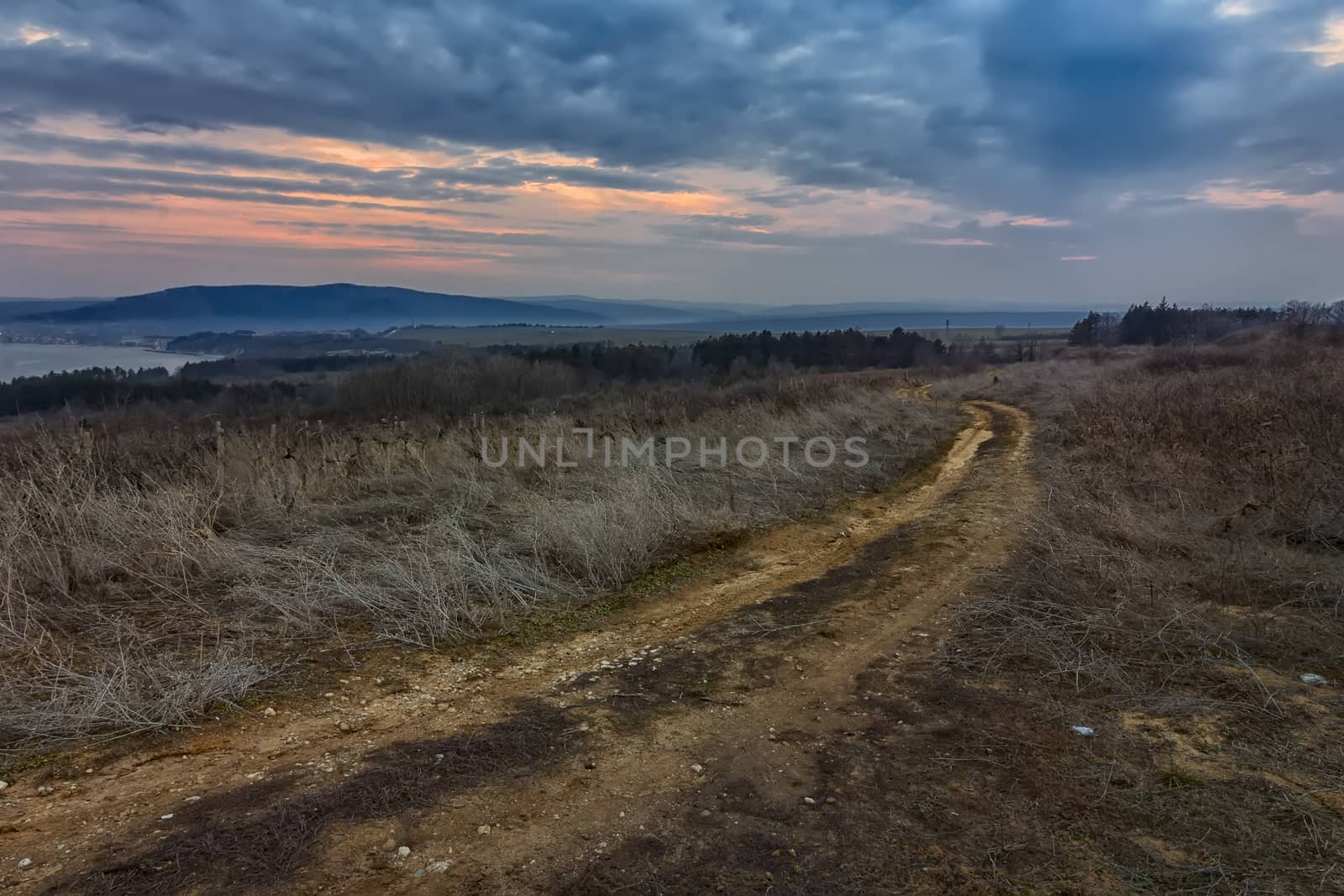 beautiful landscape on rural road at cloudy sunset