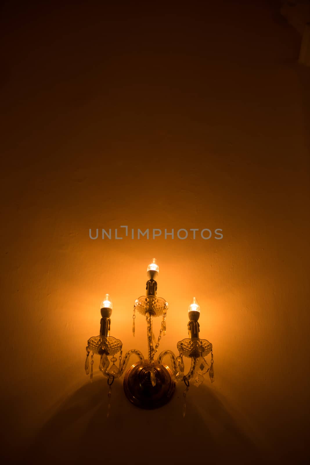artificial candlesticks illuminating dark wall background