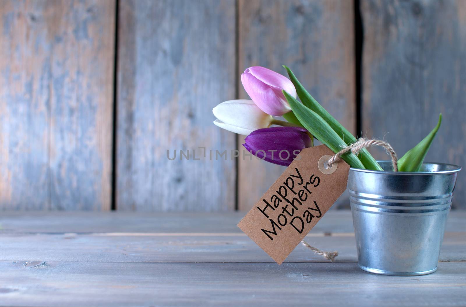 Mothers day tulips in a pot wooden background with space with gift label