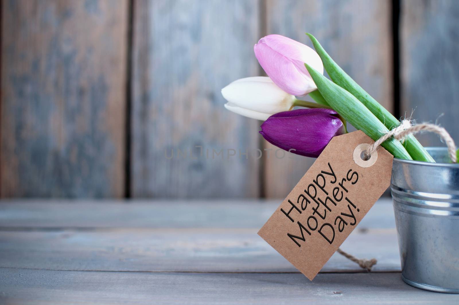 Mothers day tulips in a pot wooden background with space with gift label