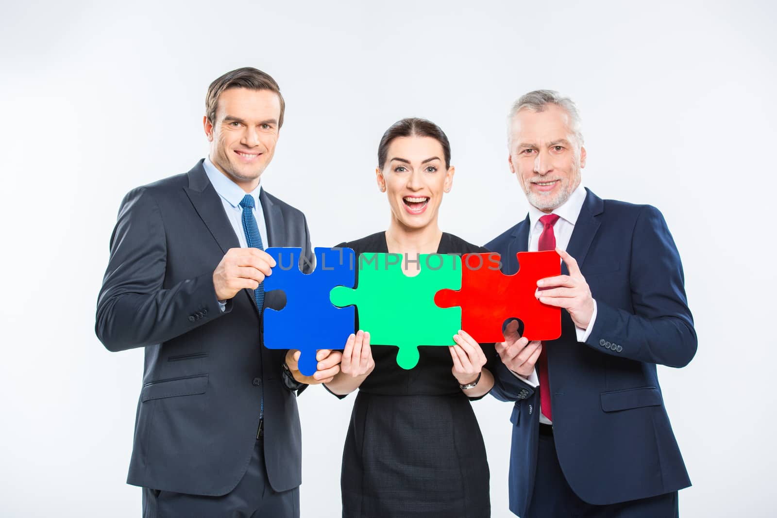 Businesspeople holding puzzle pieces by LightFieldStudios