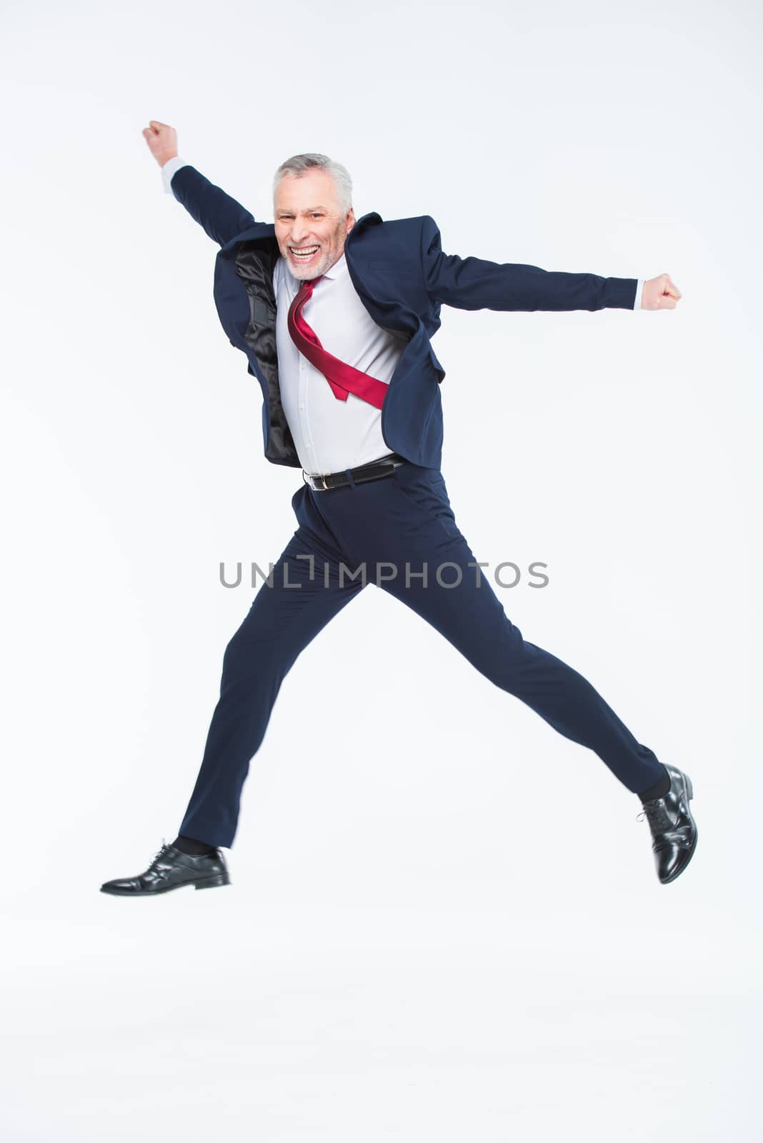 Mature businessman jumping by LightFieldStudios