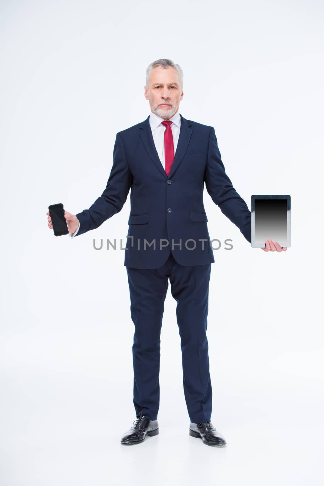 Mature businessman with devices by LightFieldStudios