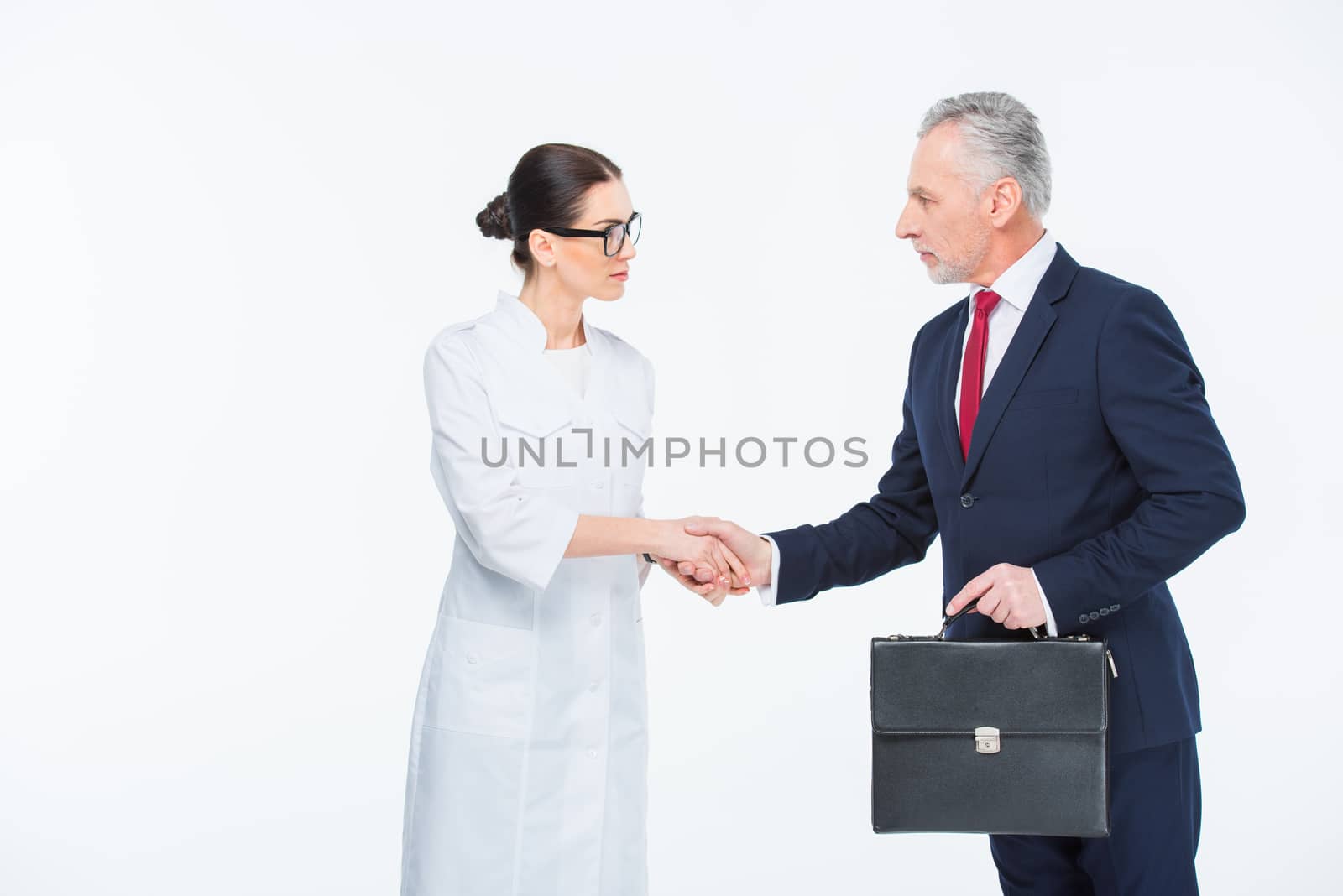 Businesspeople shaking hands by LightFieldStudios