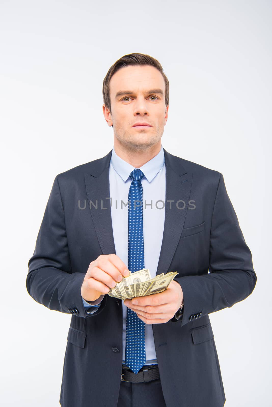 Young businessman with money  by LightFieldStudios