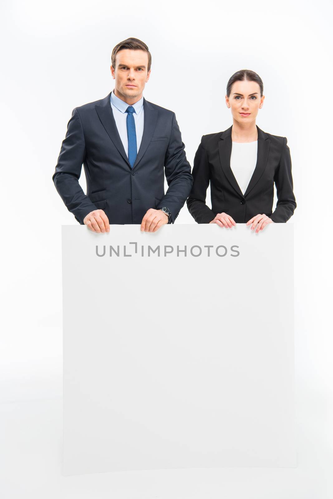 Businesspeople holding blank card by LightFieldStudios