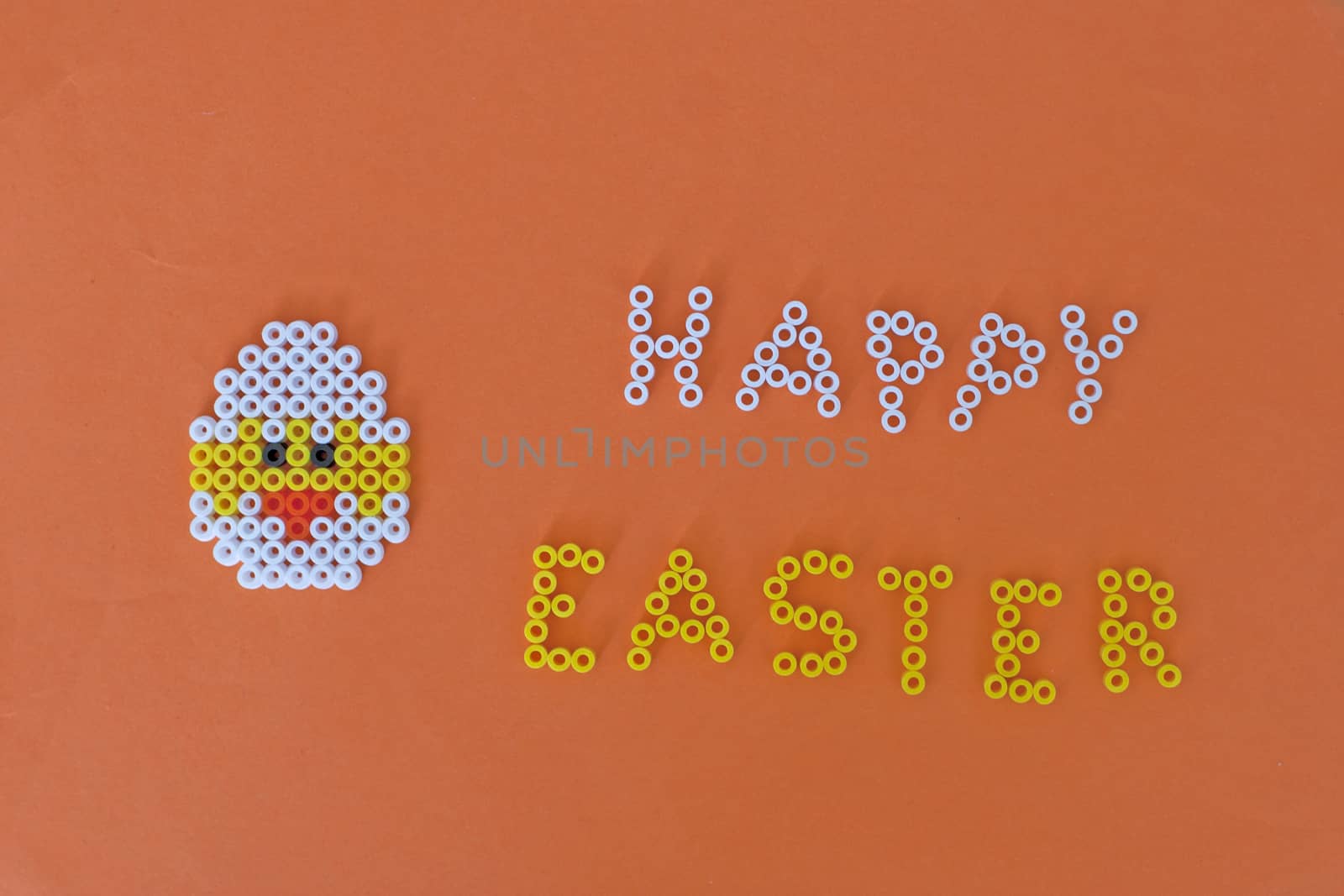 beaded chicken on an orange background with "HAPPY EASTER" made out of beads