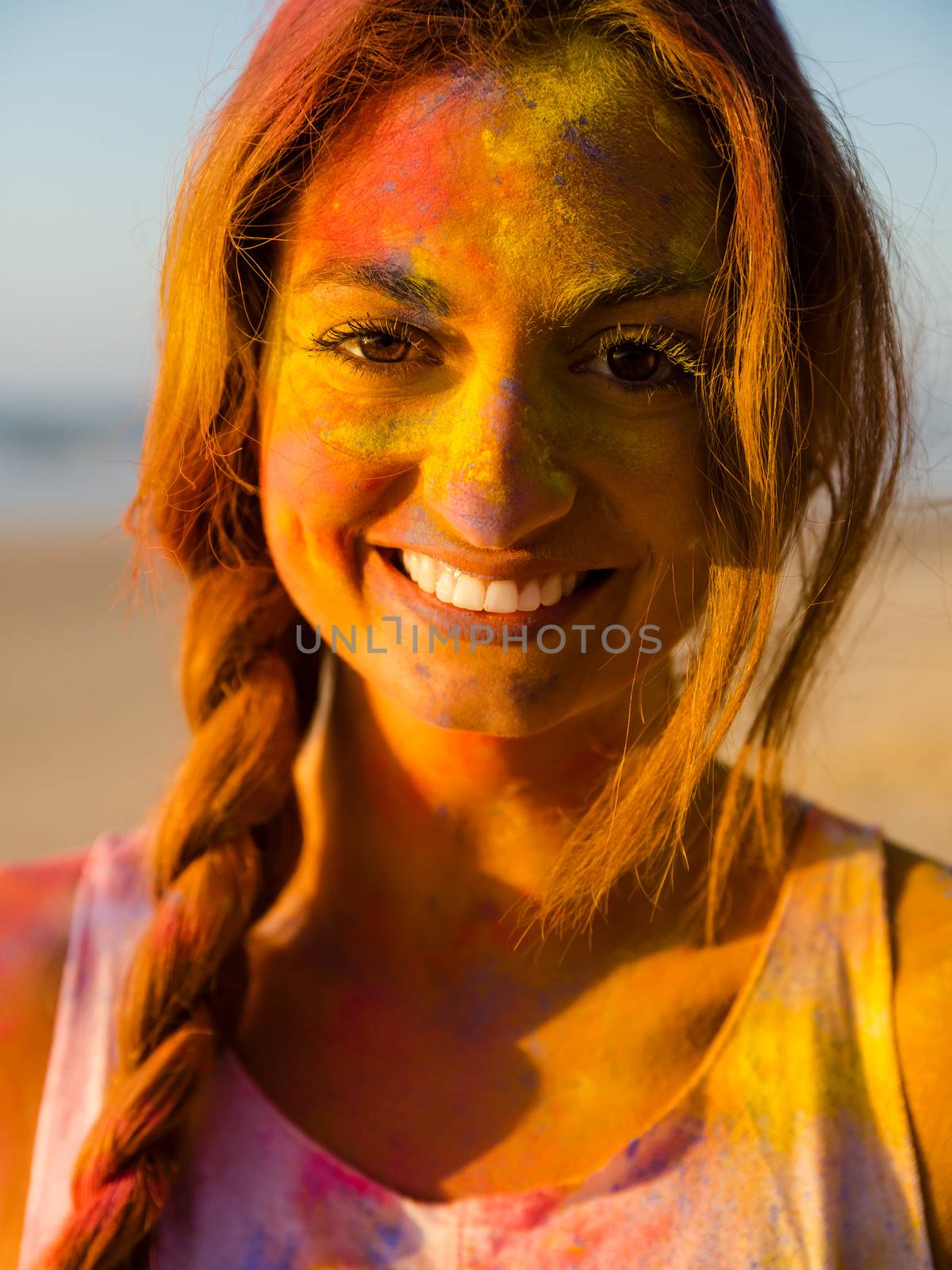 Portrait of a beautiful girl full of colored powder on the face
