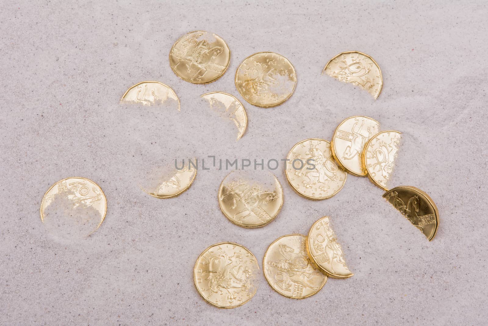 Gold coins on a grey sand background