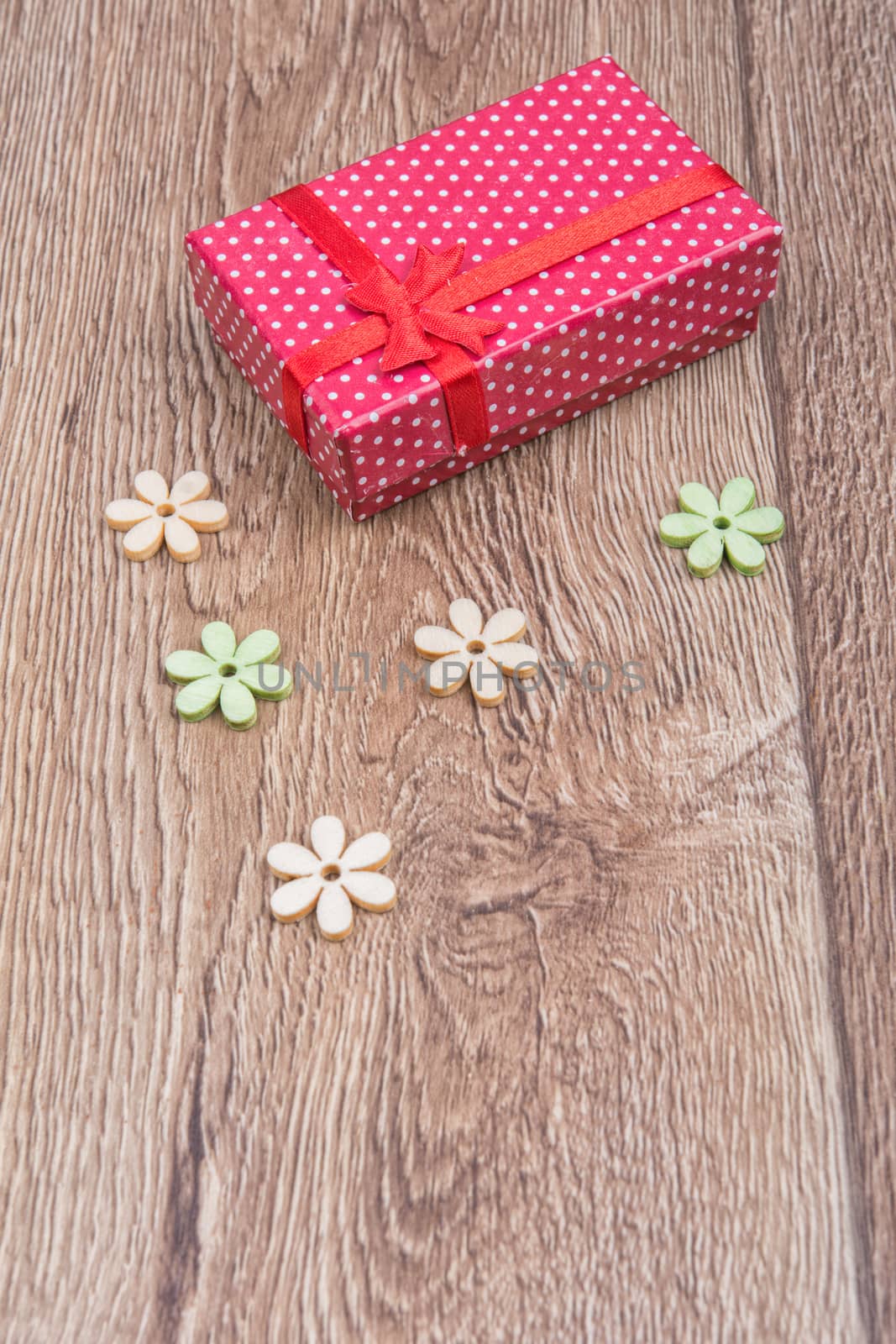 Gift with wooden flowers on a wooden background