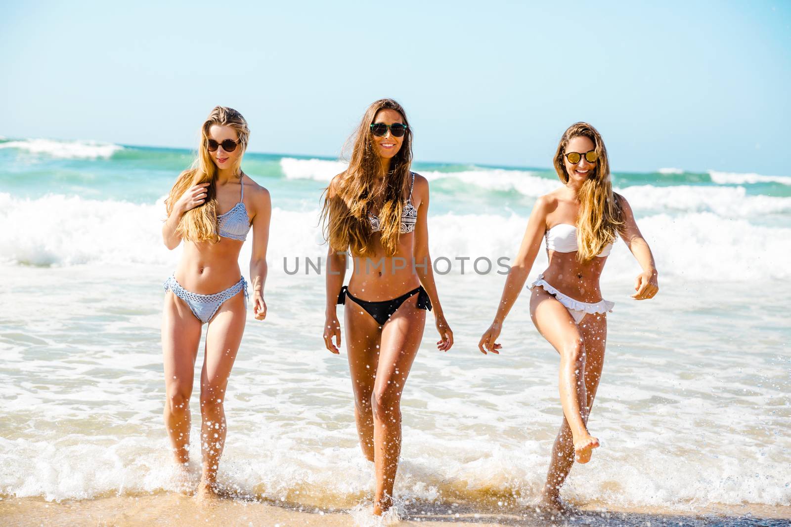 Beautiful girls in the beach having fun on the water