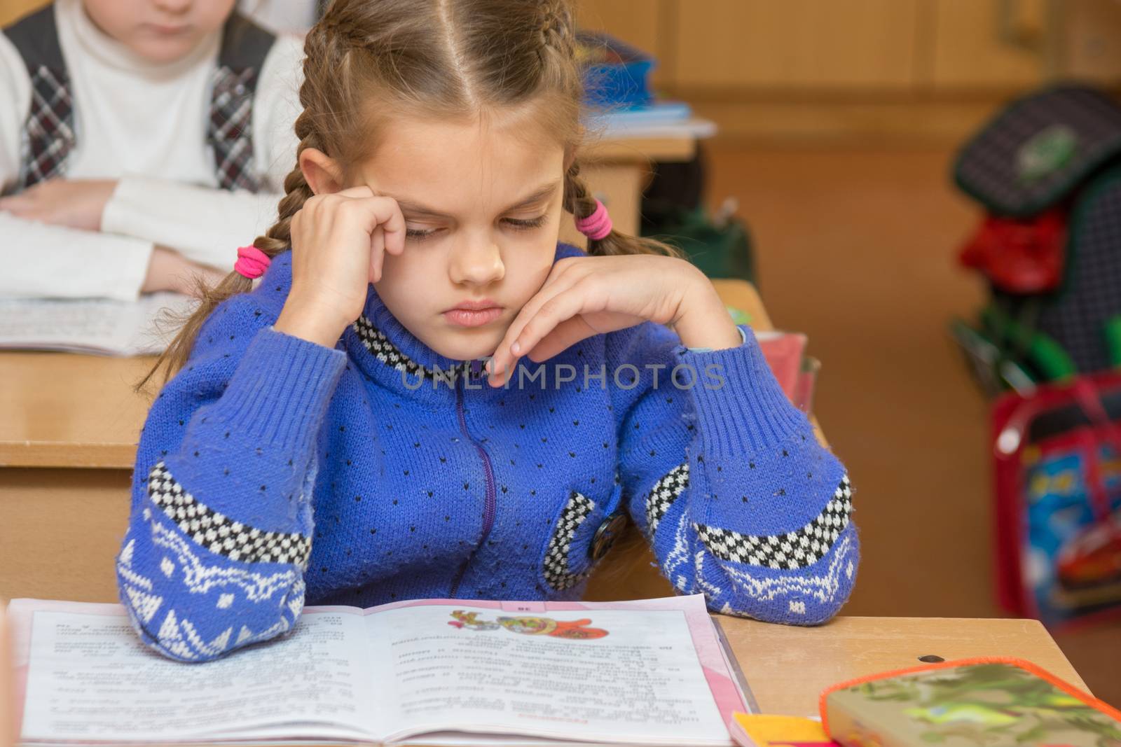 First grader girl feels bad in the classroom at school