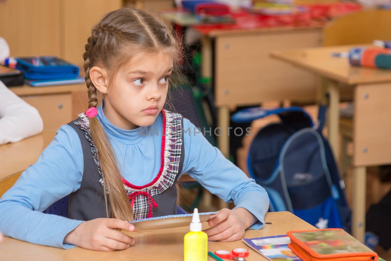 Girl in school to the labor class has not understood the task and with a puzzled looking at teacher by Madhourse