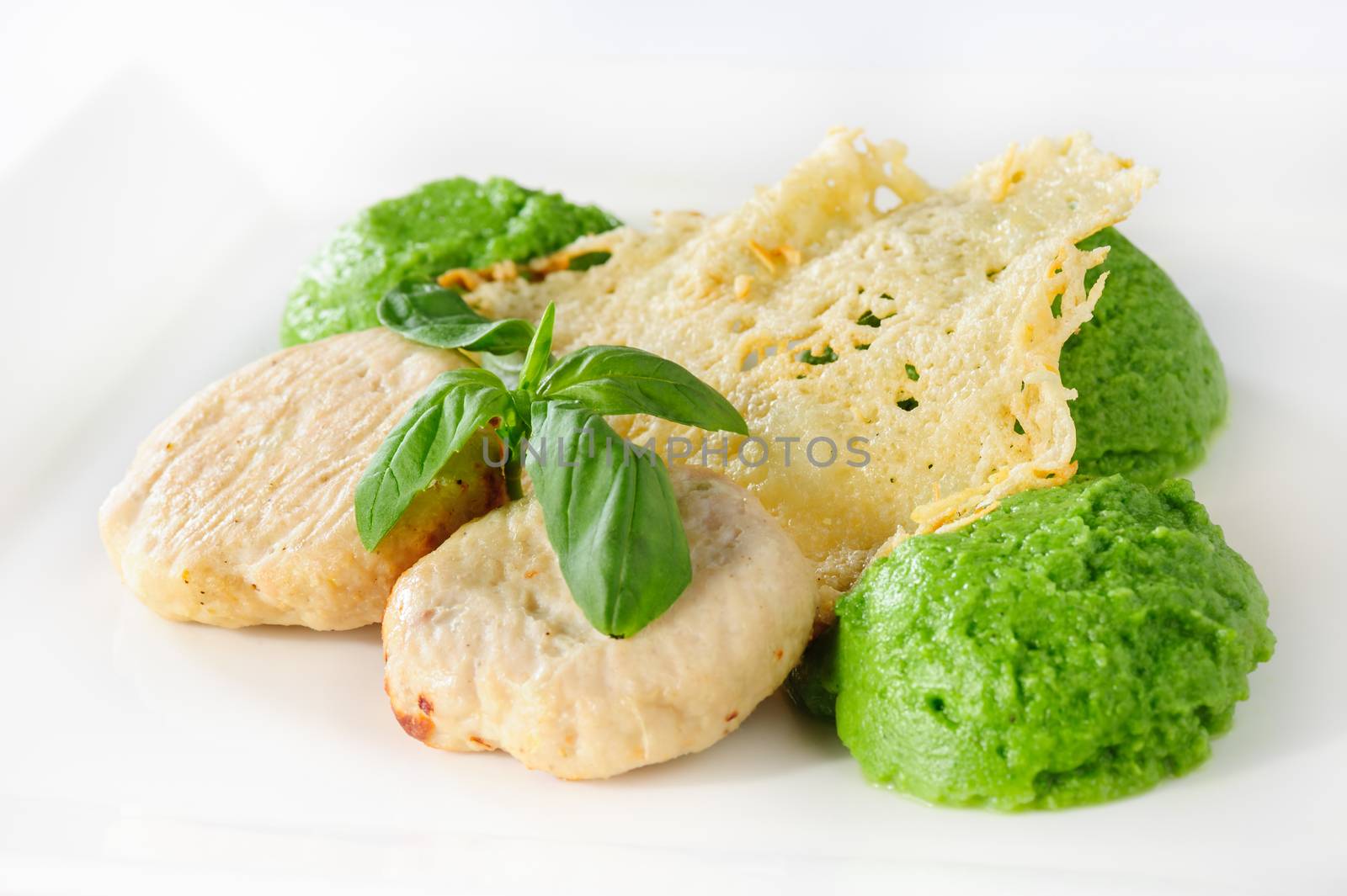 Steamed meatballs with green potato-broccoli puree and basil leaves