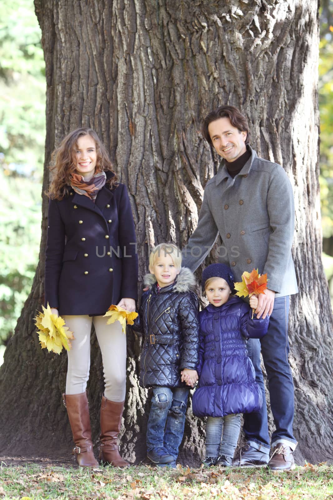 Happy family in autumn park by ALotOfPeople