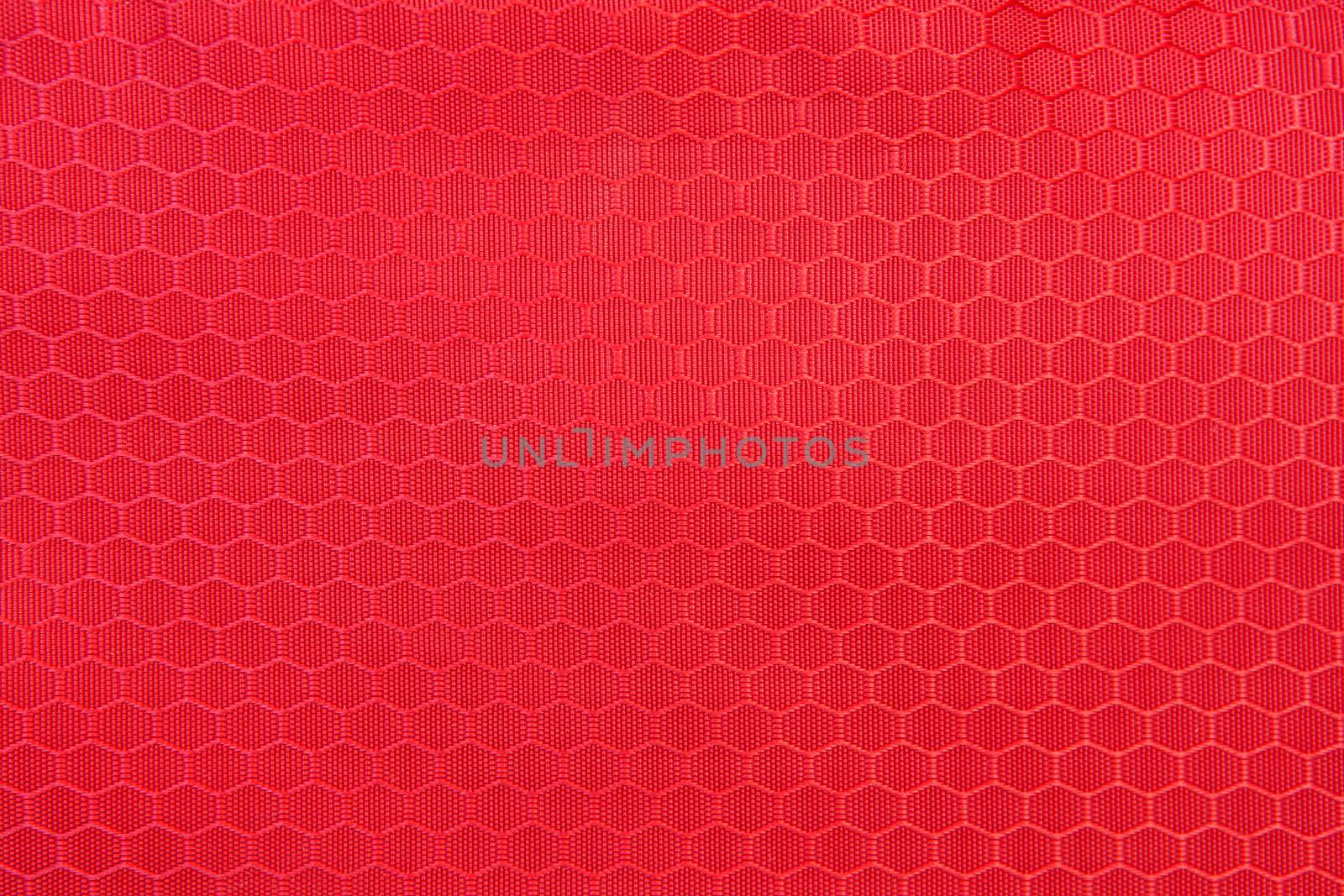 red honeycomb background texture. Texture background of polyester fabric. Plastic weave fabric pattern