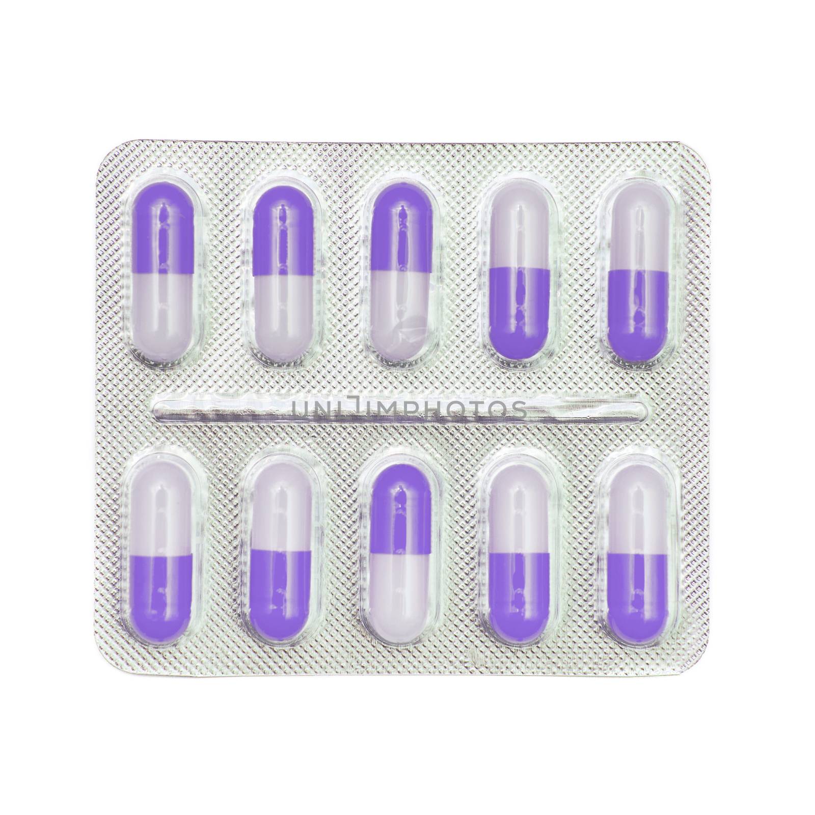 Blister pack of violet and white capsules isolated on white by natazhekova