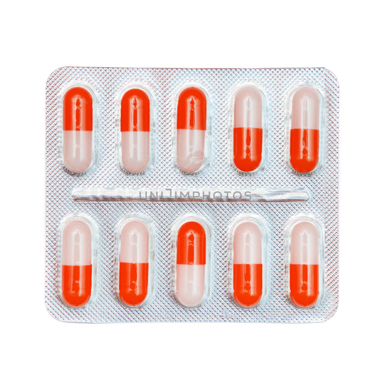 Blister pack of red and white capsules isolated on white background.