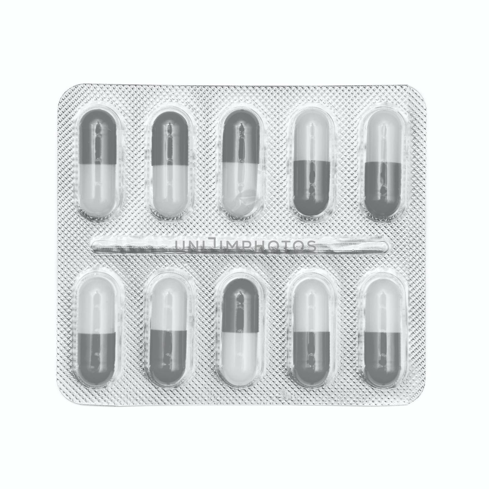 Blister pack of gray and white capsules isolated on white background.