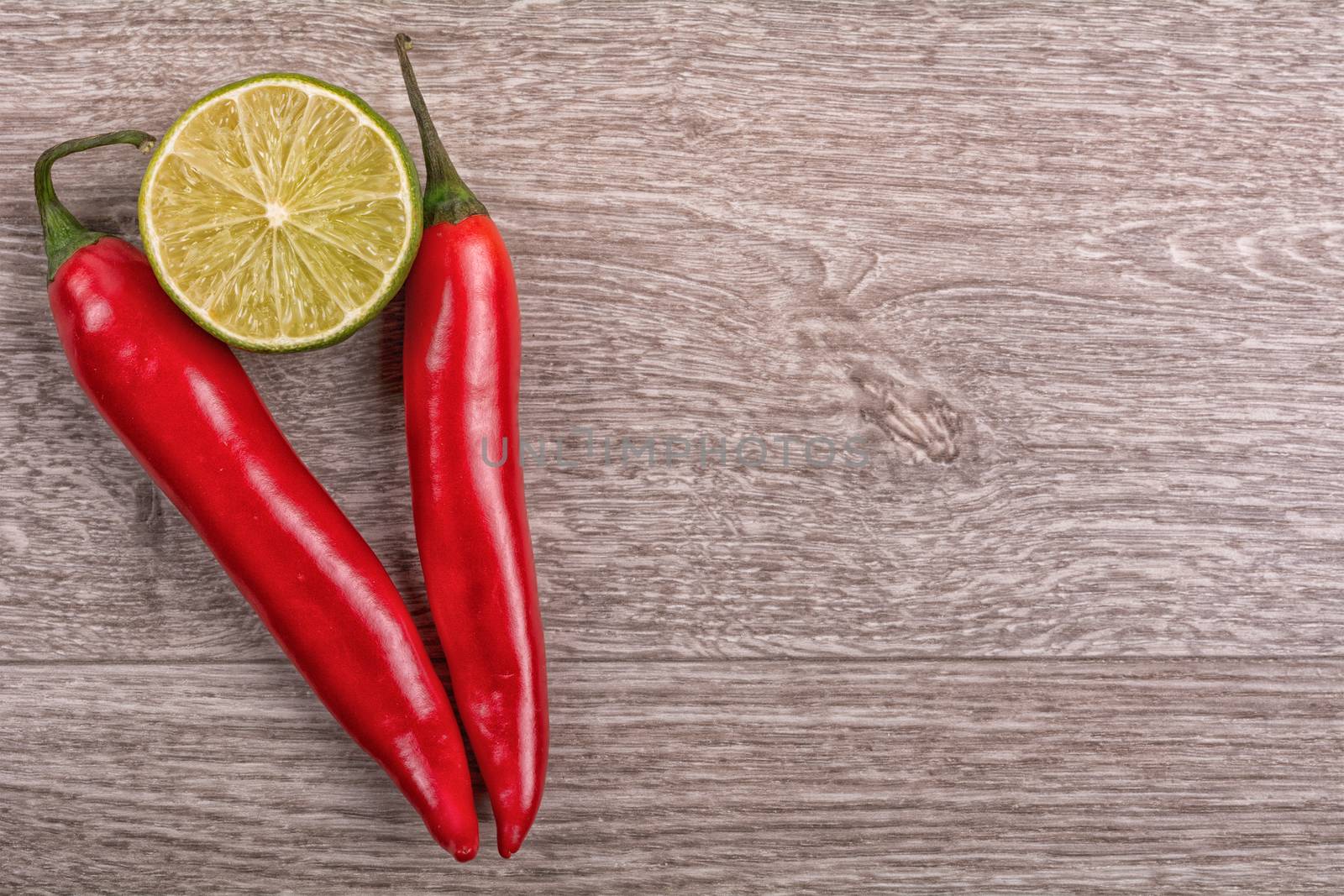 Red chilli and lime on a wooden background