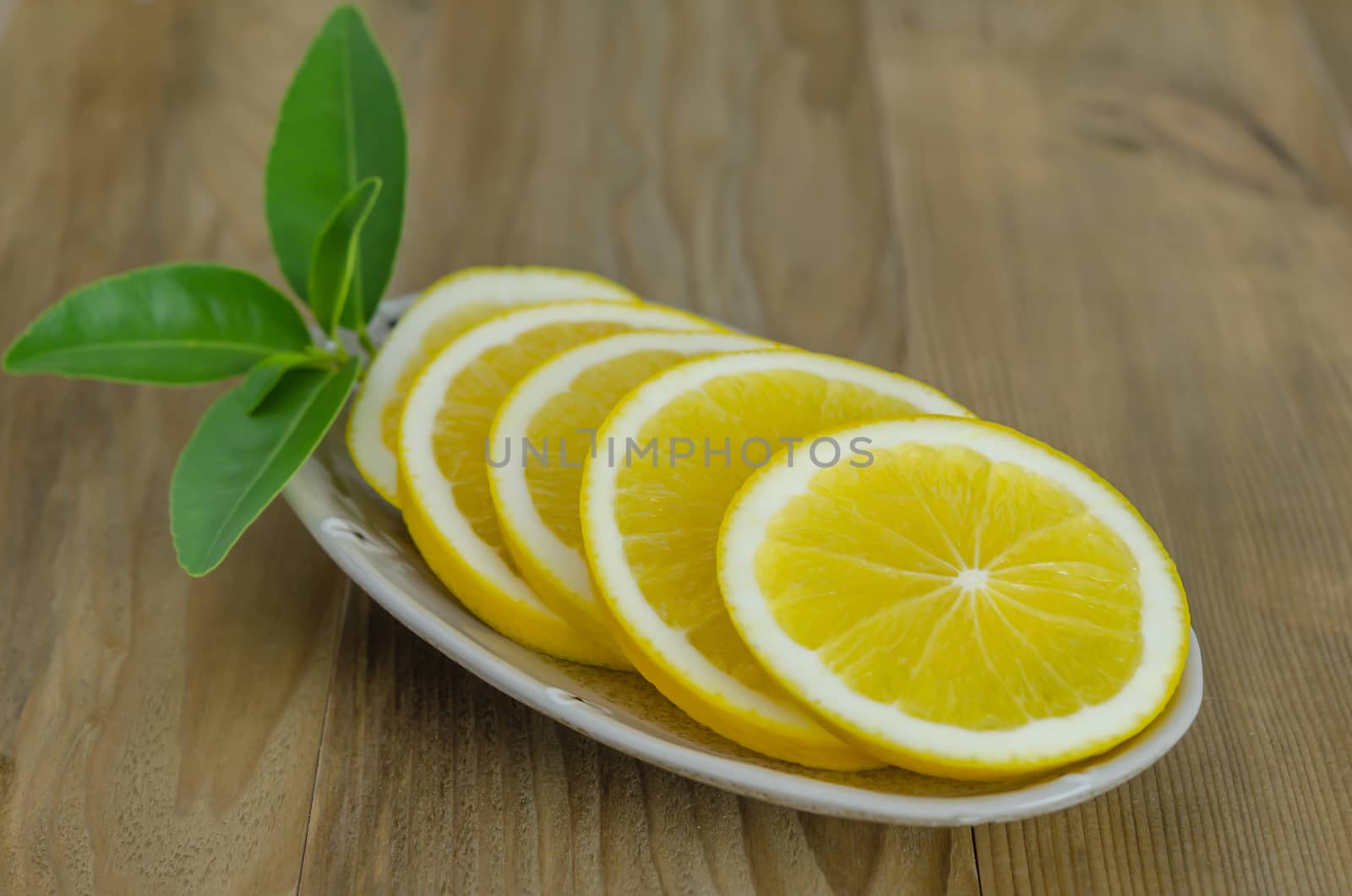 slice orange on dish over wooden background