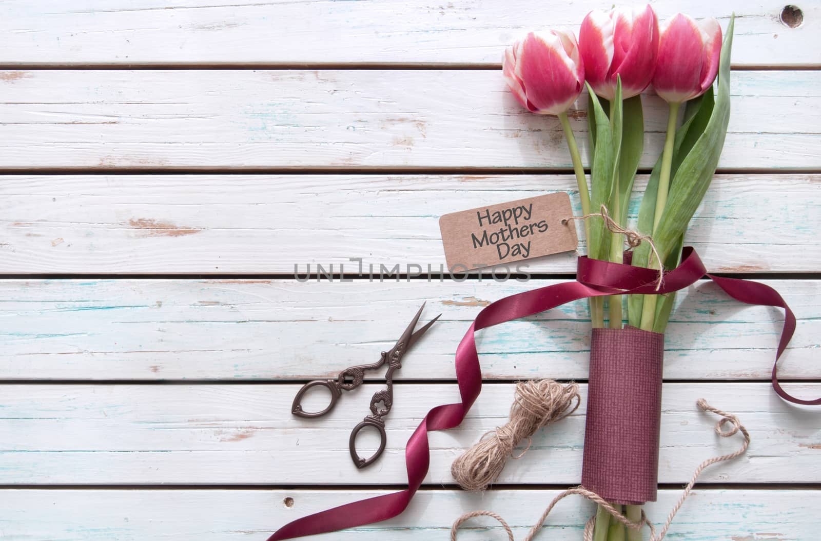 Tulips on a wooden background wtih gift tag