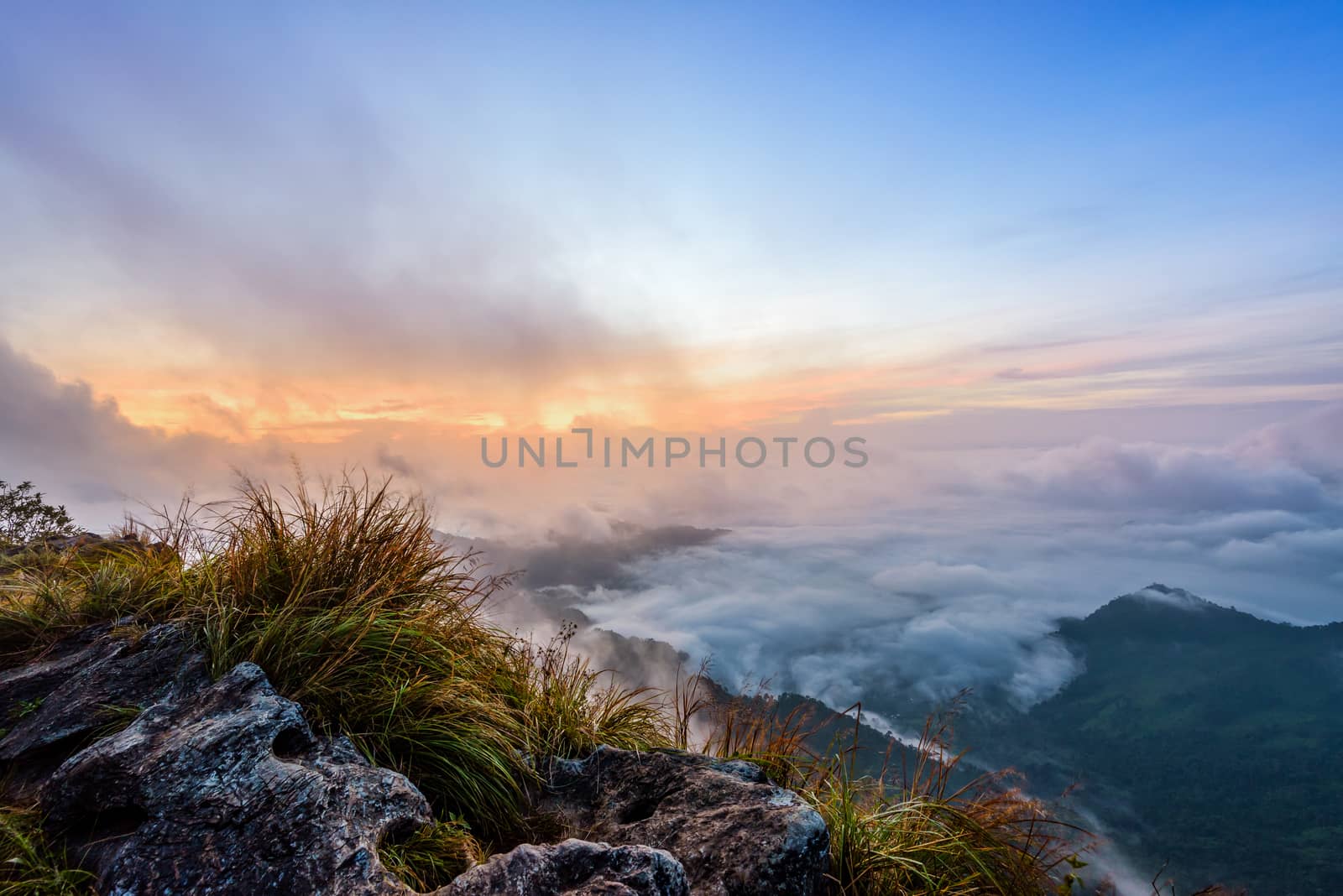Beautiful landscape nature, sunrise on peak mountain with sun cloud fog and bright colors of sky in winter at Phu Chi Fa Forest Park is a famous tourist attraction of Chiang Rai Province, Thailand