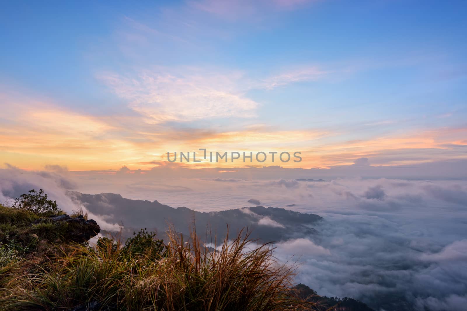 Beautiful landscape nature, sunrise on peak mountain with sun cloud fog and bright colors of sky in winter at Phu Chi Fa Forest Park is a famous tourist attraction of Chiang Rai Province, Thailand