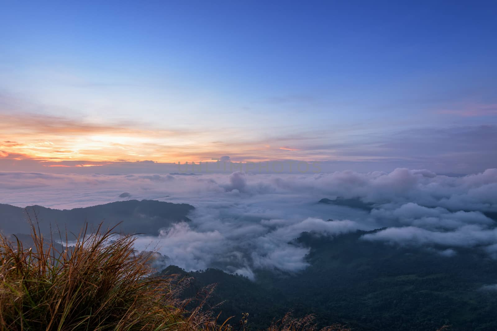 Beautiful landscape nature, sunrise on peak mountain with sun cloud fog and bright colors of sky in winter at Phu Chi Fa Forest Park is a famous tourist attraction of Chiang Rai Province, Thailand