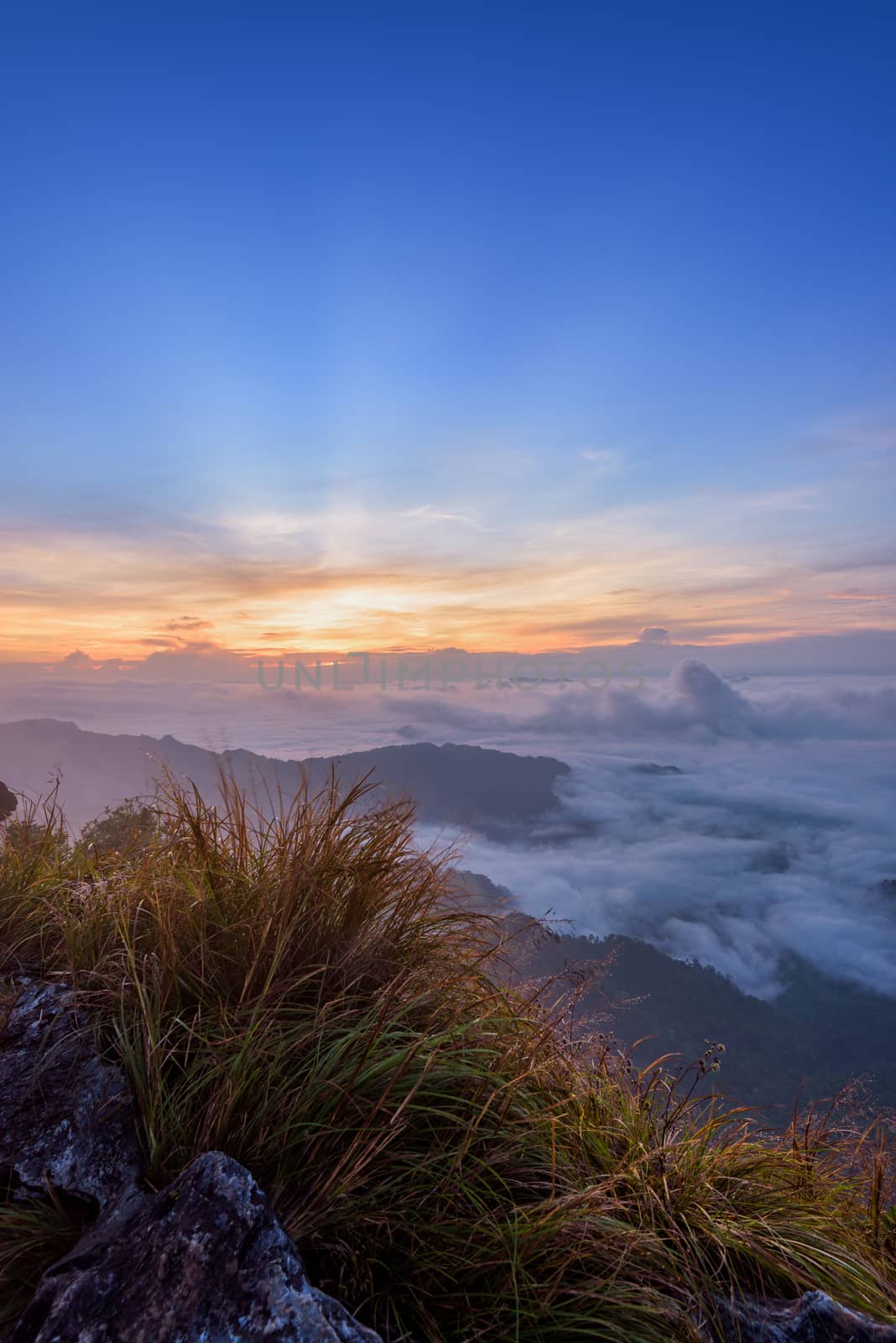 Beautiful landscape nature, sunrise on peak mountain with sun cloud fog and bright colors of sky in winter at Phu Chi Fa Forest Park is a famous tourist attraction of Chiang Rai Province, Thailand