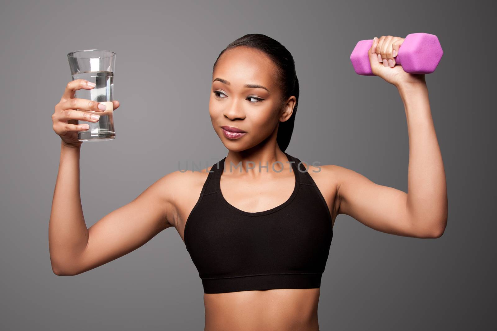 Happy healthy black asian woman with water and dumbbell by phakimata