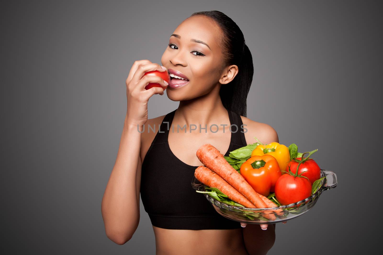 Beautiful healthy happy black asian woman eating delicious vegetables.