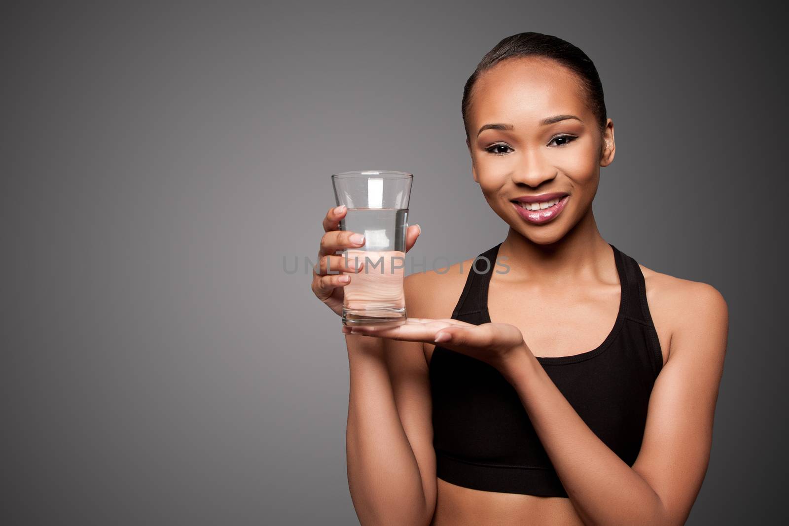 Beautiful happy smiling healthy black asian woman with glass of water, skincare concept.