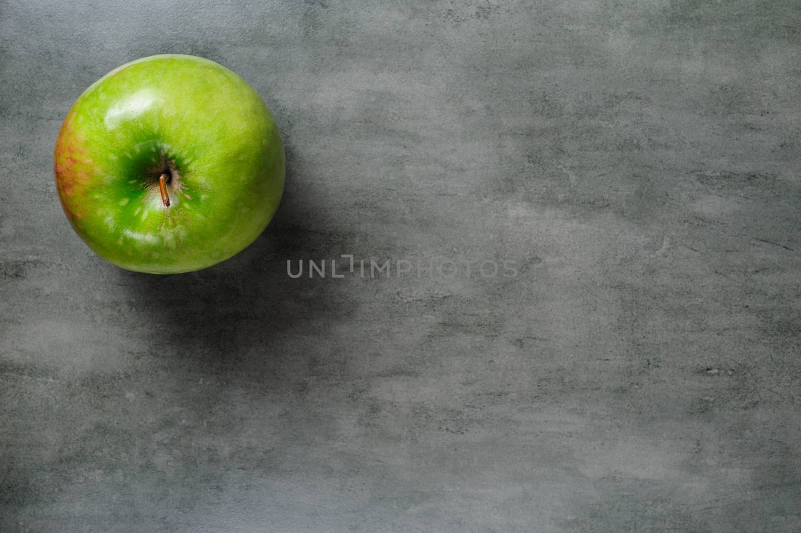 one green apple ripe pears on dark stone background, top view, copy space