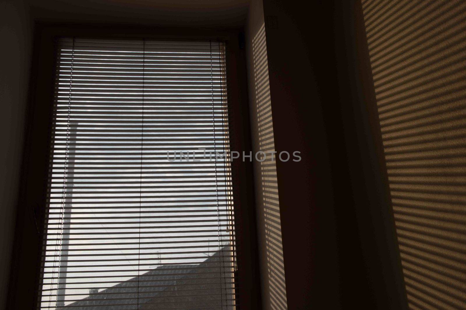 shade of venetian blind on the wall, subject shadow on the wall, shadow wallpaper, shadow. Light falls on a subject and creates shadows on the wallpaper in the room.