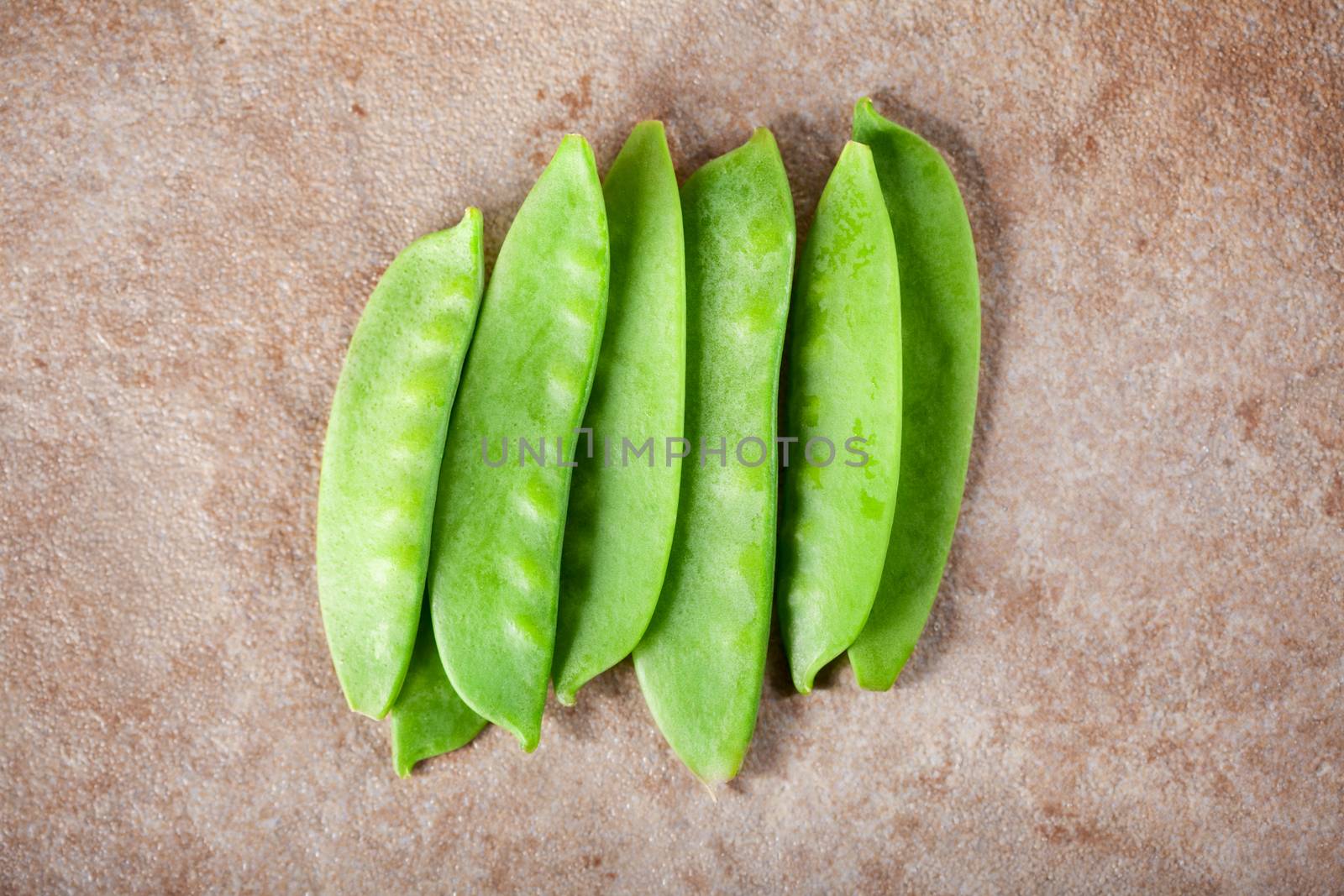 Green Sugar snap peas on ceramic surface