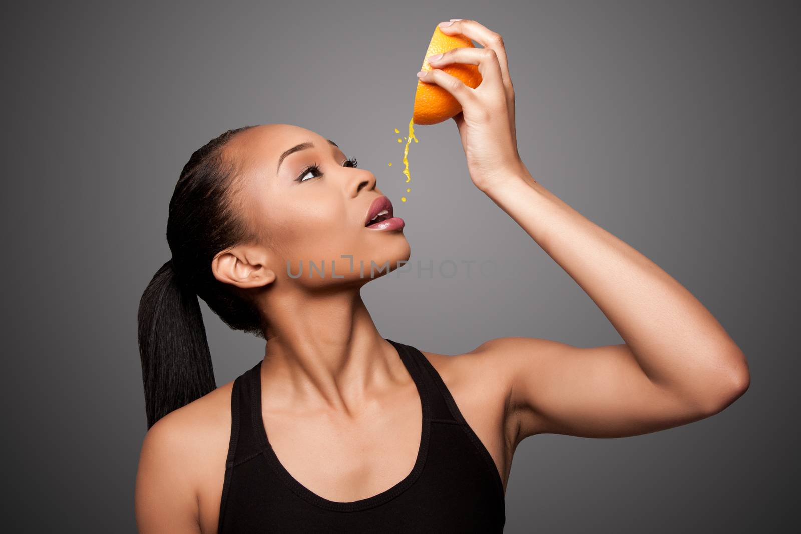 Beautiful healthy happy black asian woman squeezing delicious orange juice mandarin fruit.