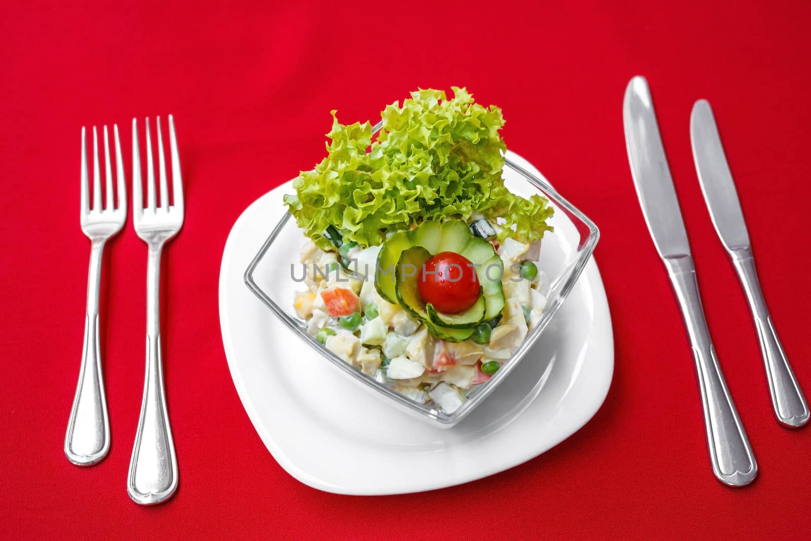Salad with fresh vegetables, served on the table. On a red tablecloth close-up