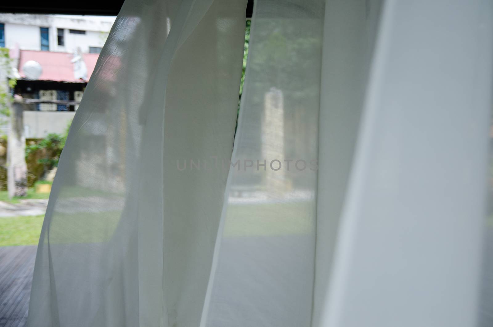 Background with transparent tulle curtain. View on the street from house