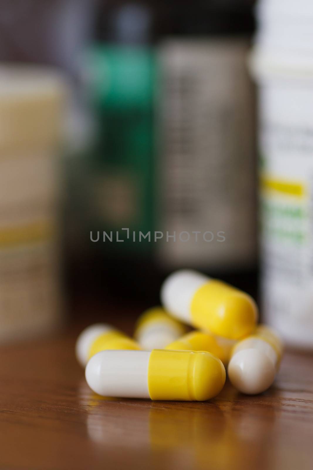 Yellow-white capsules with medications on the bedside table, close-up