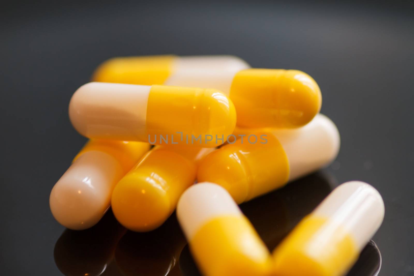 Yellow-white capsules on a dark background close-up